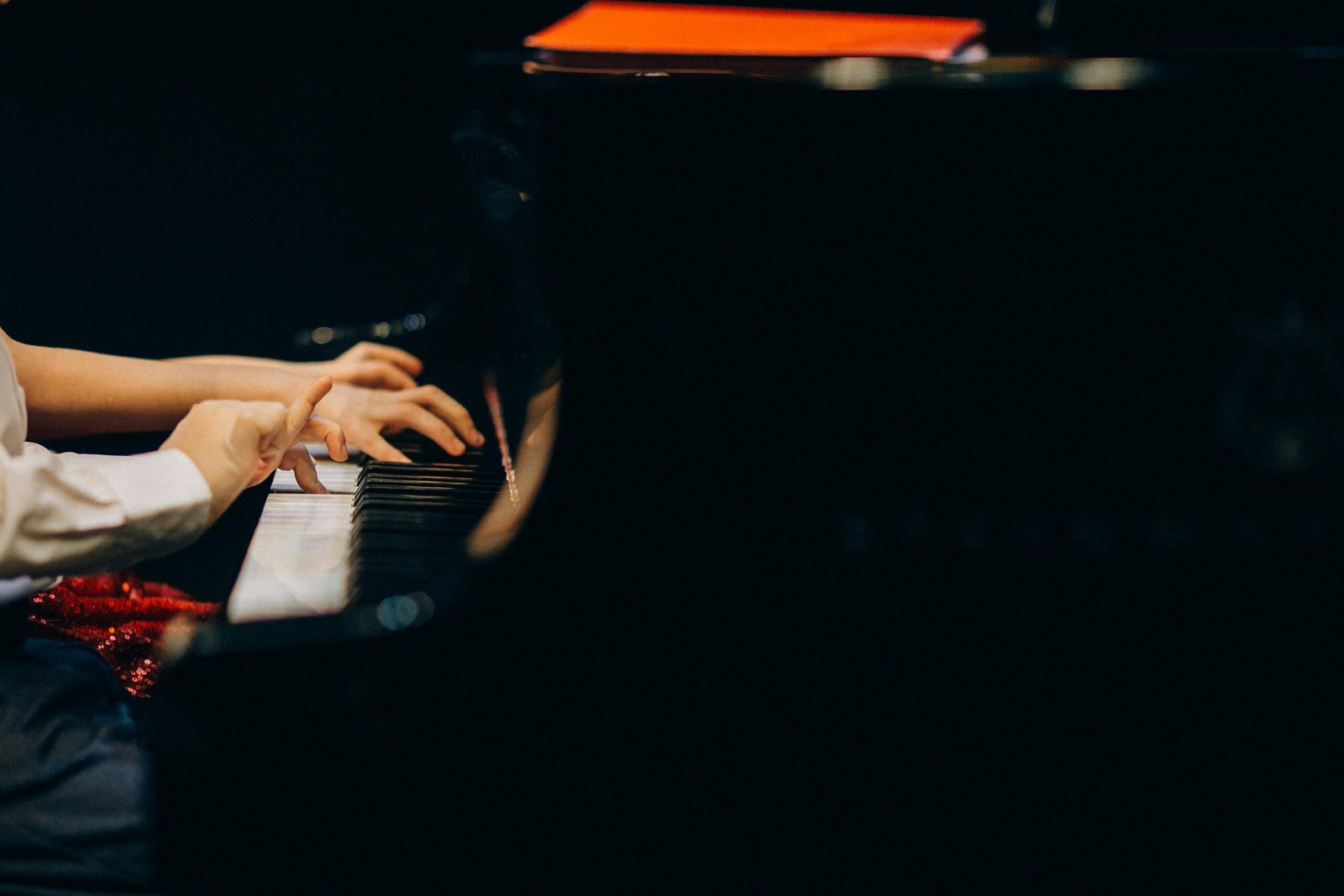 A detailed view of hands playing piano keys during a musical performance.
